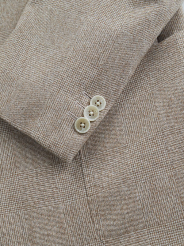 Beżowa marynarka Balamonte – detal rękawa z widocznymi guzikami w jasnym kolorze, subtelny wzór kraty.