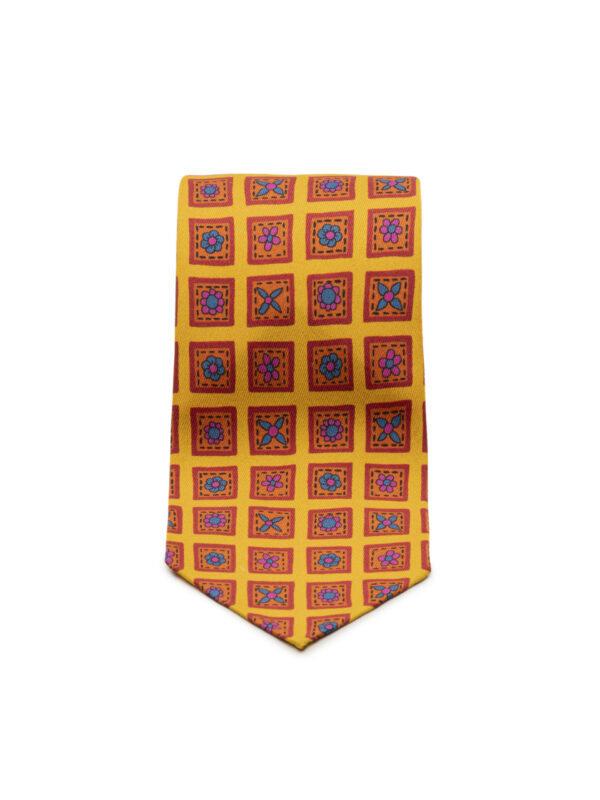 Żółto – czerwony krawat Macclesfield Balamonte – zwinięty krawat z wyraźną fakturą i klasycznym zakończeniem