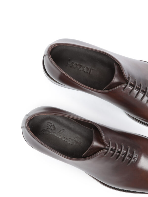 Detal wnętrza ciemnobrązowych półbutów FESTIVO – luksusowa skórzana wkładka z logo marki.