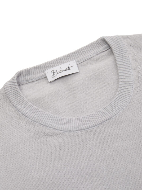 Okrągły kołnierz swetra Balamonte – detal starannie wykończonego ściągacza i metki z logo