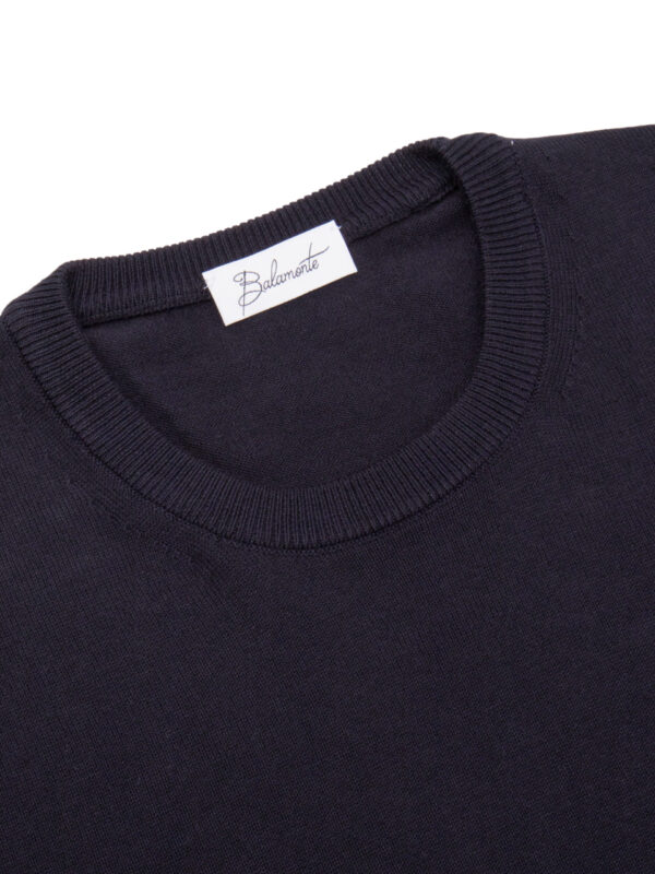 Okrągły kołnierz swetra Balamonte – detal starannie wykończonego ściągacza i metki z logo