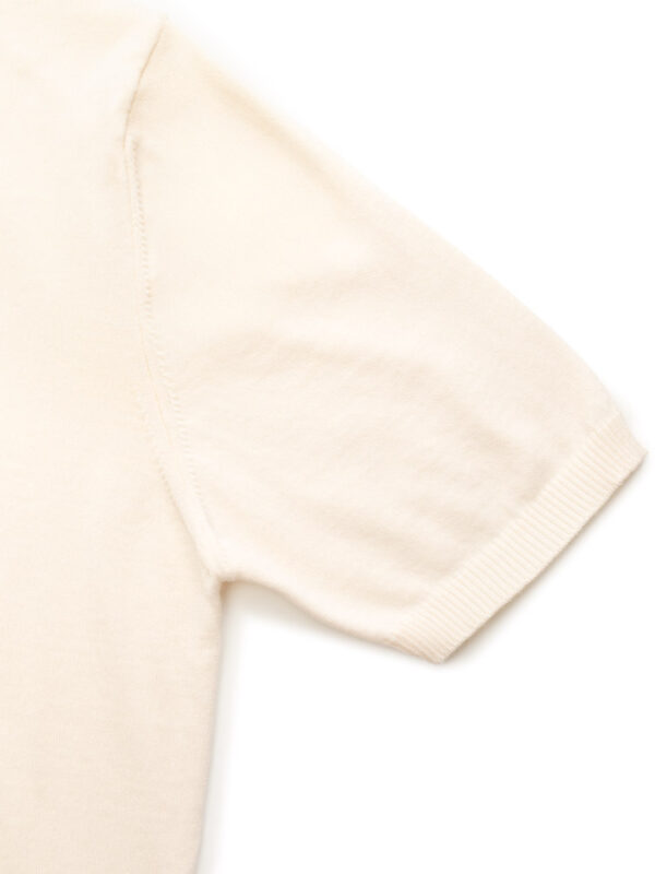 Rękaw jasnobeżowego T-shirtu z krótkim rękawem, detal szwu.