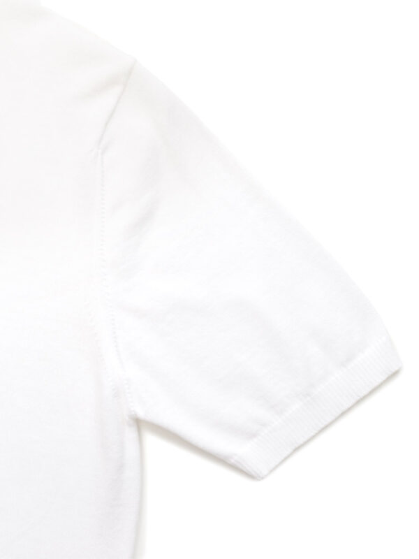 Zbliżenie na rękaw białej koszulki polo, podkreślające wykończenie ściągaczem